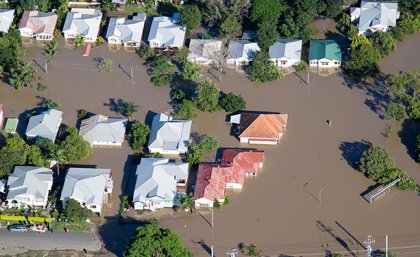 Image: Adobe. aerial view of the rooves of houses in brown floodwater